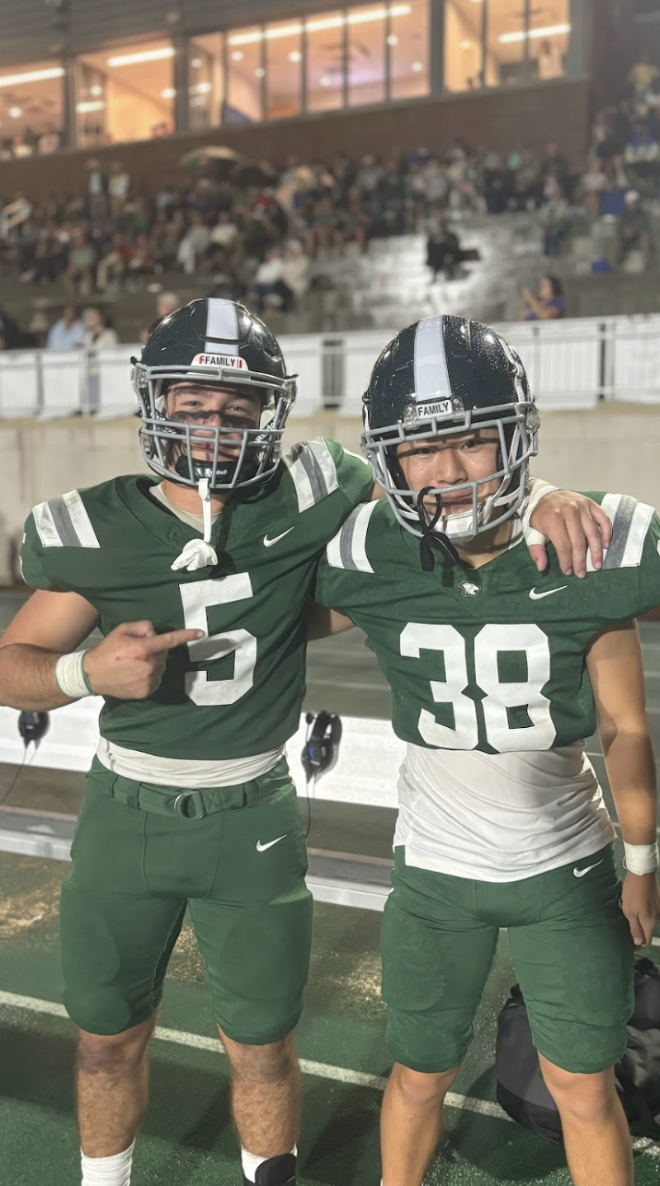 Football players Jonah Franco (#5) and Eric Na (#38) pose for the camera after halftime.